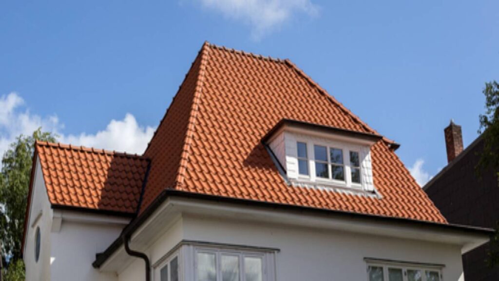Een dakkapel op een landhuis met oranje dakpannen.