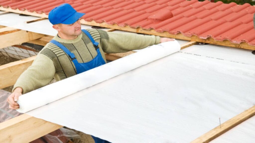 De dakwerker is bezig met het werken aan isolatiemateriaal.