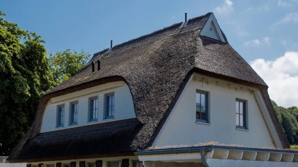 Een wit huis met rieten dak straalt klassieke charme uit.
