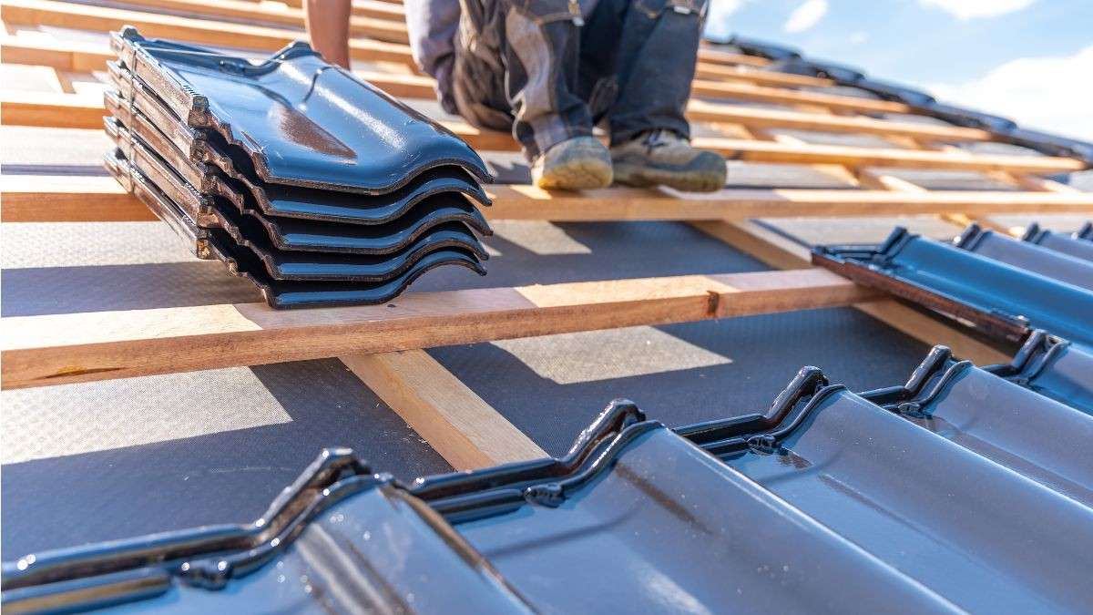 Dakwerker plaatst geglazuurde keramische dakpannen op houten panlatten met zichtbaar onderdak en dampscherm