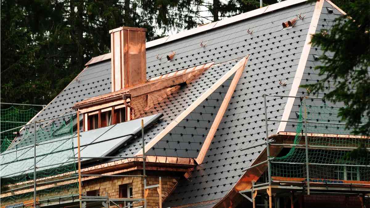 Renovatie van een schilddak met leien dakbedekking, koperen aansluitingen en een dakkapel op de voorgevel