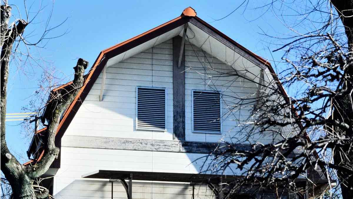 Hedendaags mansardedak met lichte gevelbekleding en luiken waarbij de kenmerkende knik duidelijk zichtbaar is