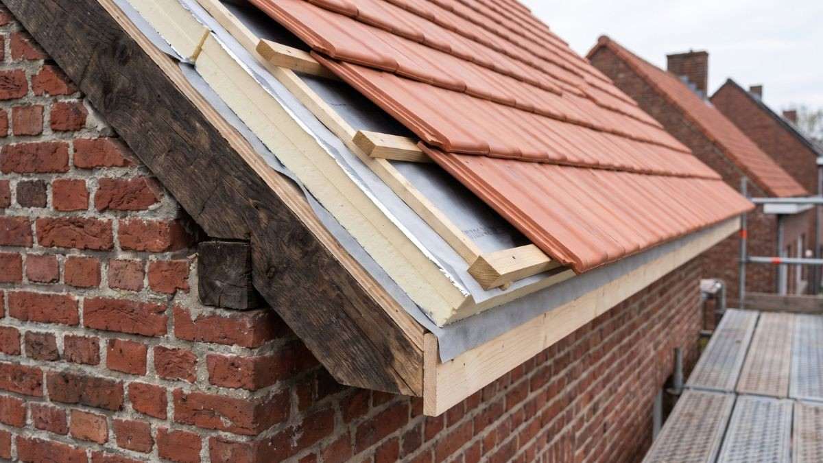 Detail van een dakrand met isolatie bovenop de kepers, dampopen onderdak, tengellatten en nieuwe dakpannen bij sarking