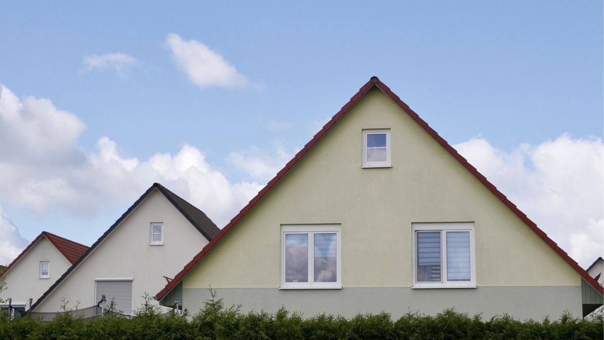 Woningen met een klassiek hellend dak en rode dakpannen, waarbij de puntgevels met ramen naast elkaar in de straat staan