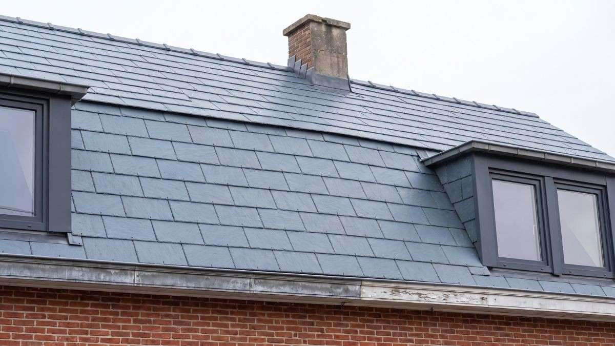 Dezelfde woning na de vervanging van het leien dak met asbest, afgewerkt met nieuwe asbestvrije leien in een strakke legging